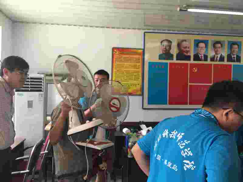 陈台子拿到修好的电扇的满脸笑容的村民